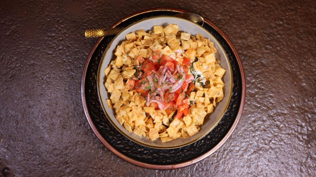 Crispy chaat topped with tomato and onion