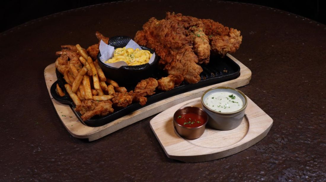 Fried chicken tenders with fries, sides and dipping sauces