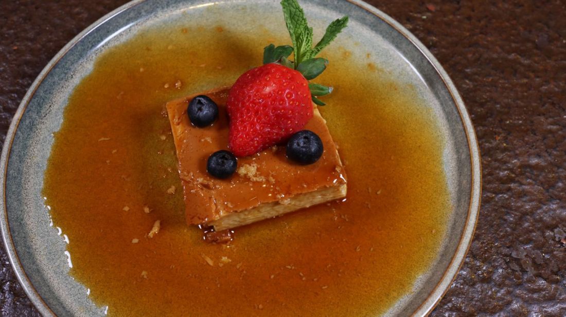 Caramel flan topped with strawberry and blueberries