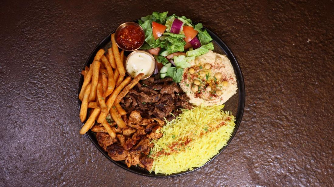 Mixed grill plate with fries, rice, hummus and salad