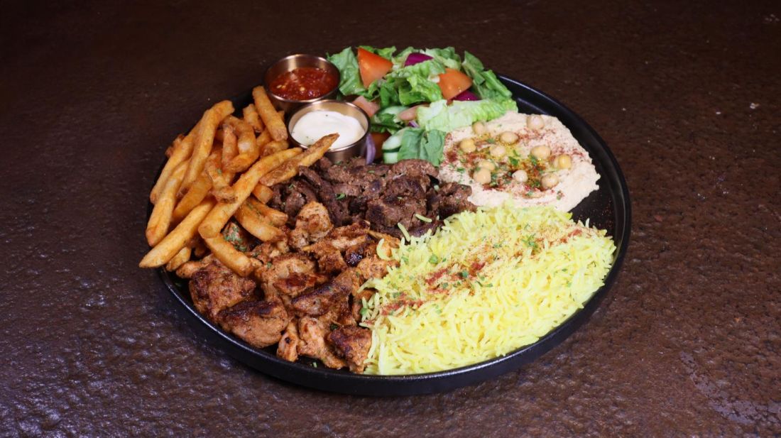Mixed grill plate with fries, rice, hummus and salad